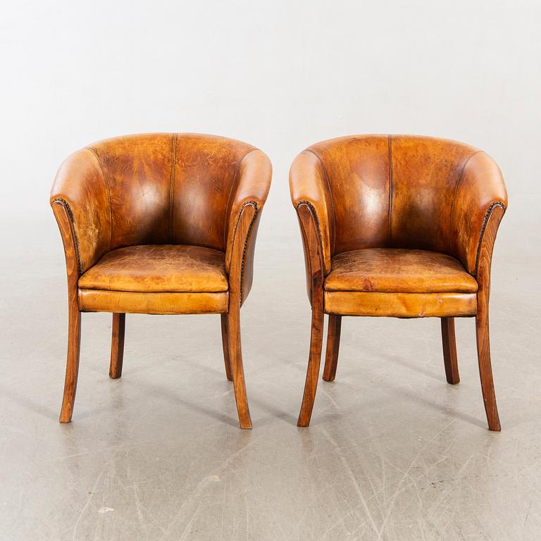 A pair of leather armchairs later part of the 20th century.