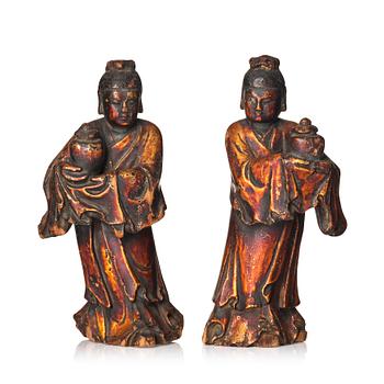 1198. A pair of wooden gilt lacqer figures of officials carrying vases, 17/18th century.