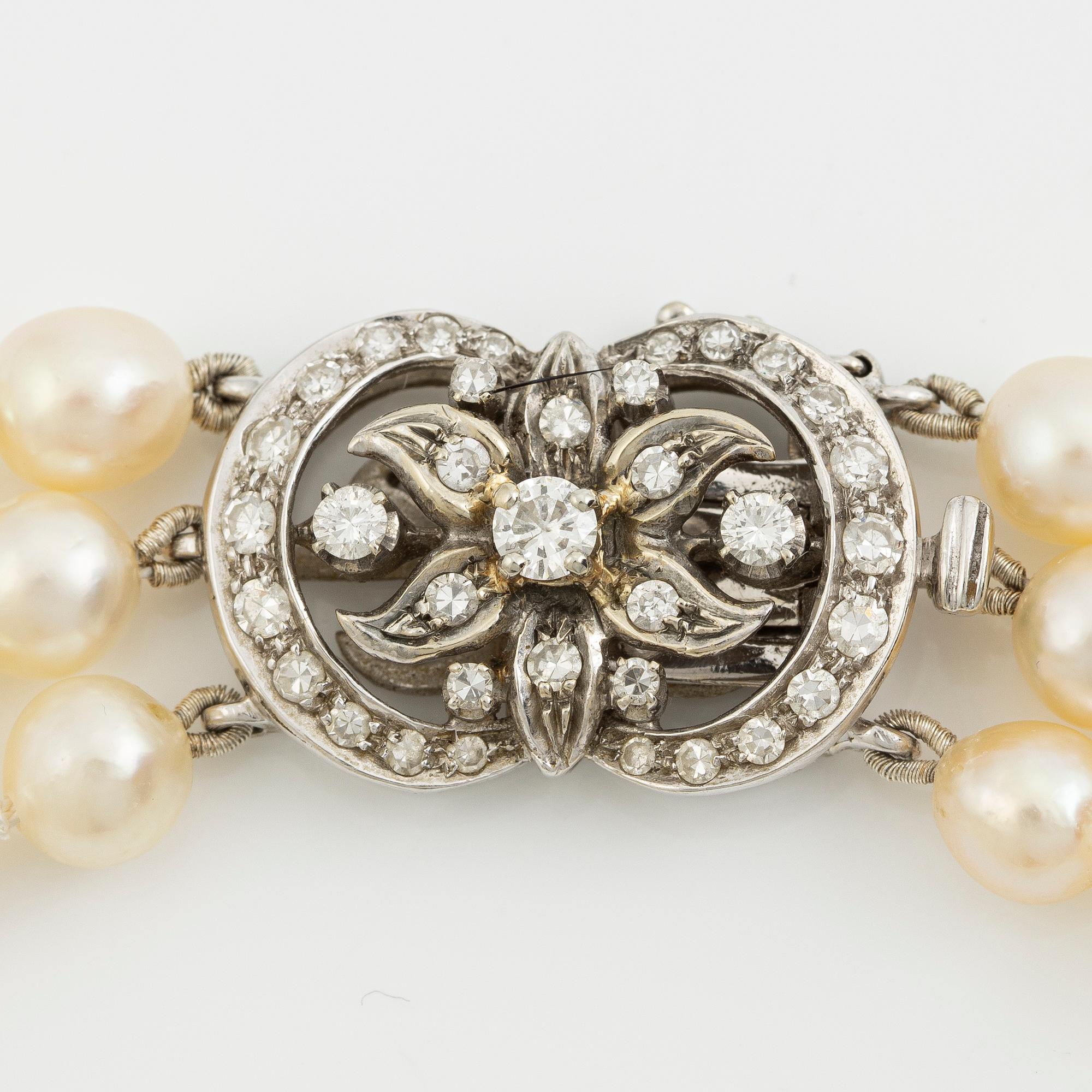 Necklace of cultured pearls, clasped in 18K gold with round brilliant-cut and eight-cut diamonds.
