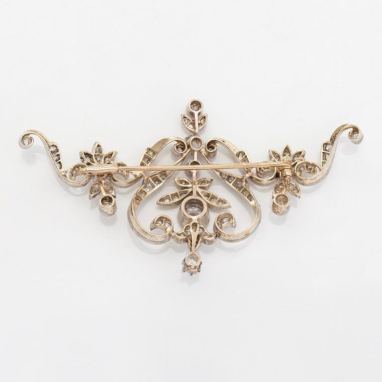 A 14K gold and silver brooch, with an old European brilliant, old mine- and rose cut diamonds.