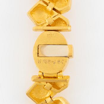 Garnityr av guldsmycken, en collier (14K), ett armband (18K), ett par örhängen (14K) och en ring (14K).