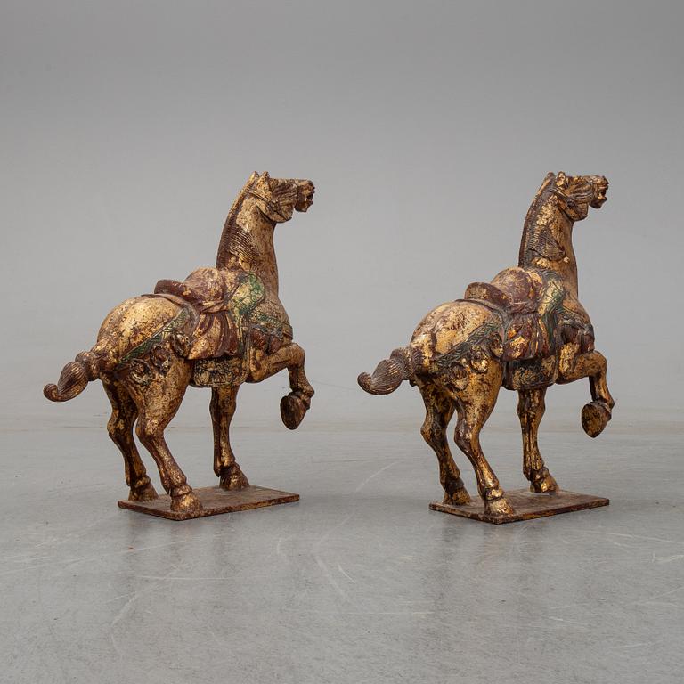 A pair of large Chinese wooden and gilt sculpture of horses, first half of the 20th century.