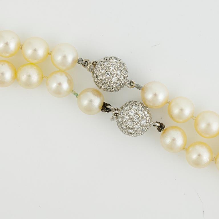 Two necklaces of cultured pearls clasp set with round brilliant-cut diamonds, 18K gold.