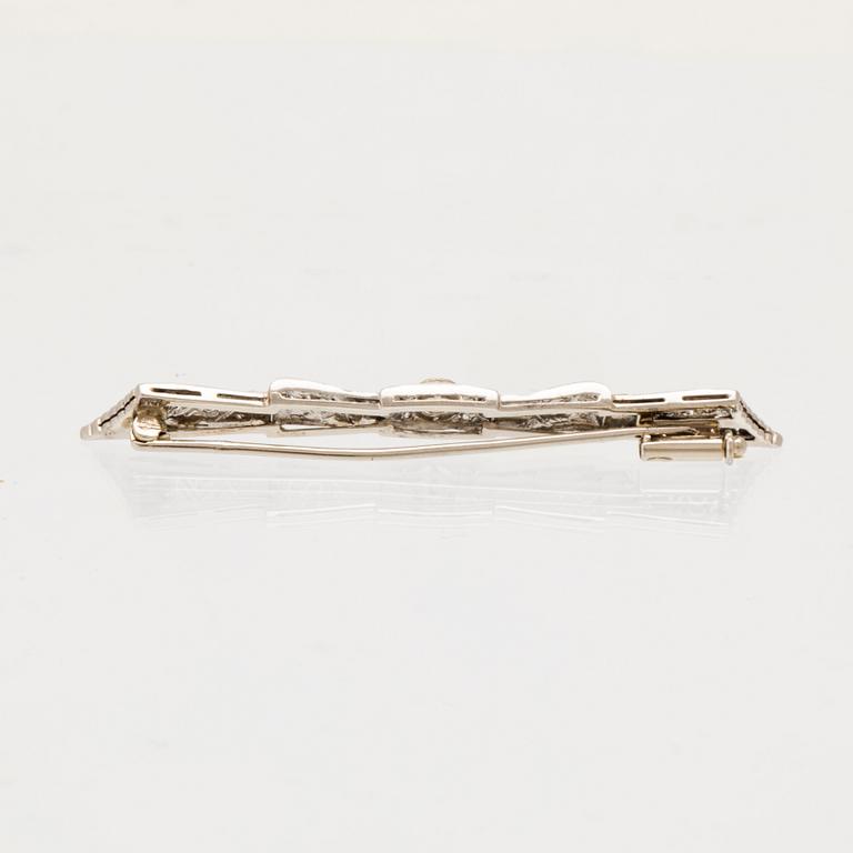 Brosch 18K vitguld med en rund briljantslipad diamant samt rosenslipade diamanter.