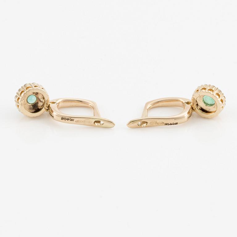 Earrings with emeralds and brilliant-cut diamonds.