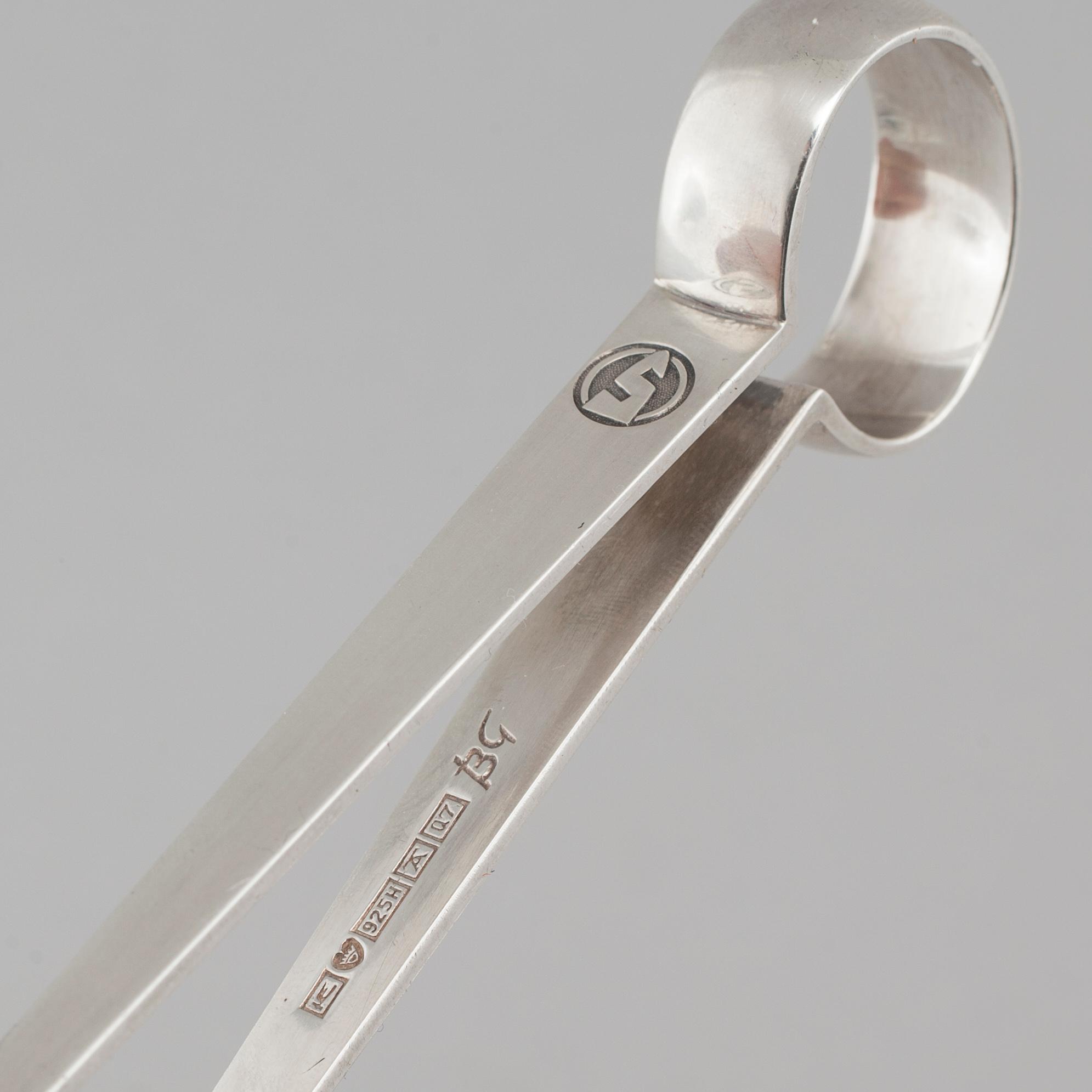 Two silver drink accessories with finnish stamps.