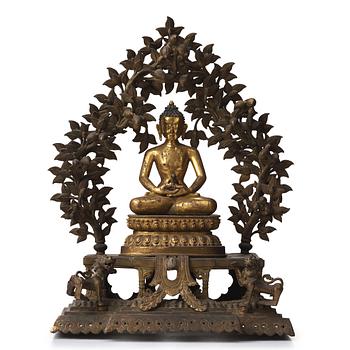 655. A large Nepalese gilt bronze buddha on a throne with mandorla, 18/19th Century.