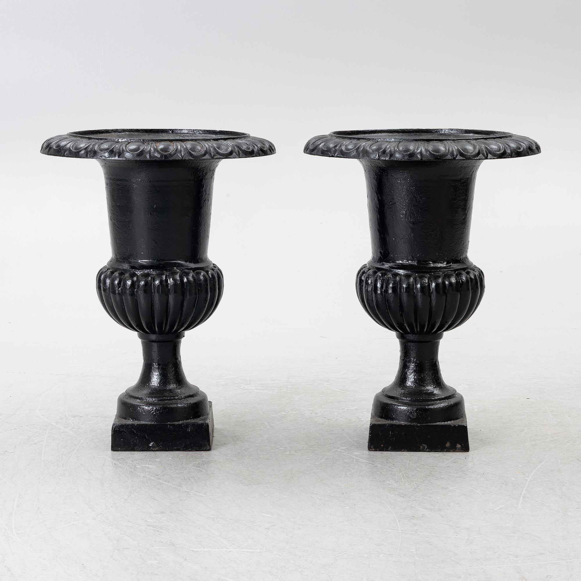 A pair of cast iron garden urns, 20th century.