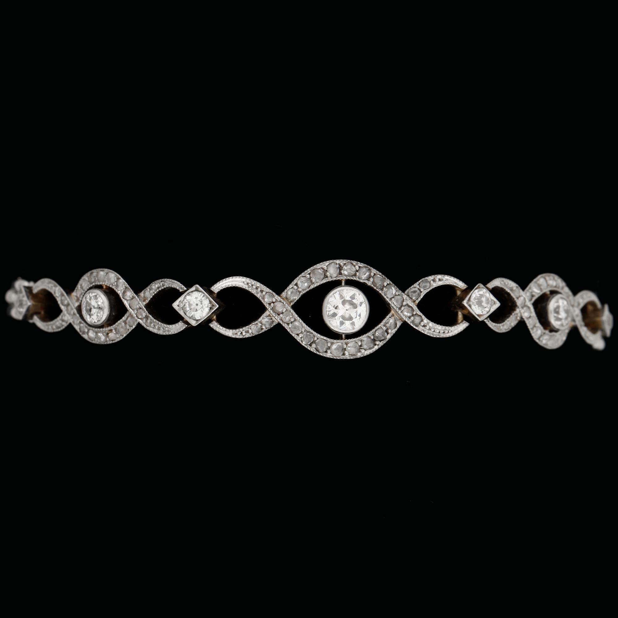 ARMBAND, 14k tvåfärgad med gammalslipade diamanter tot ca0,60ct samt rosenstenar. Tidigt 1900-tal. Vikt ca15,7g.