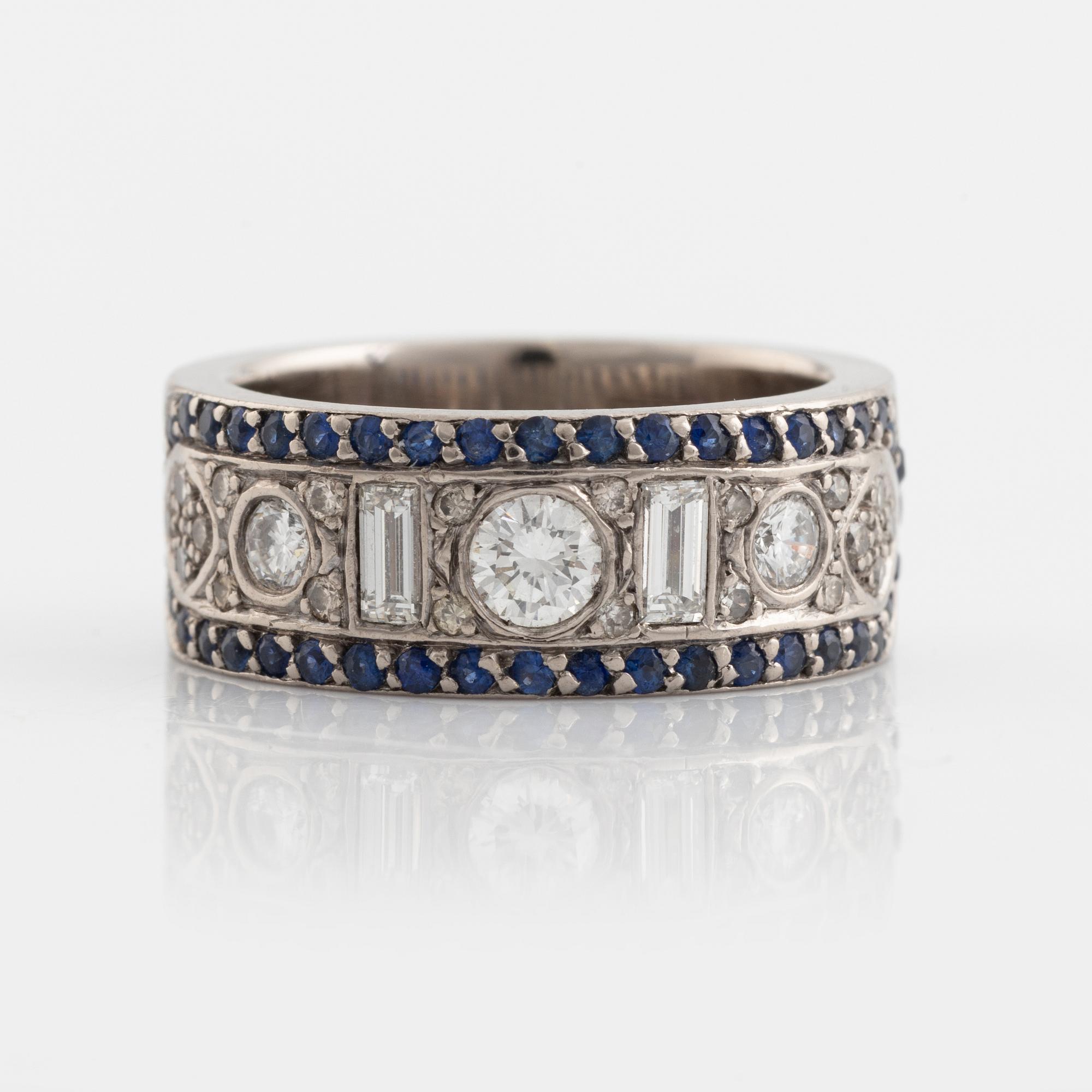 An 18K white gold ring set with diamonds, rubies and sapphires.