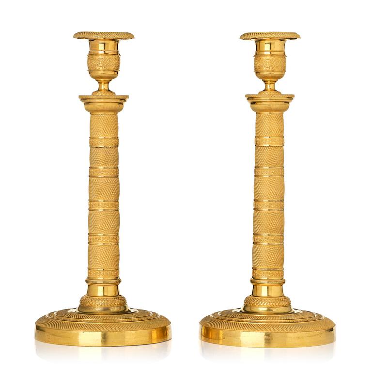 A pair of French Empire gilt-bronze candlesticks, early 19th century.