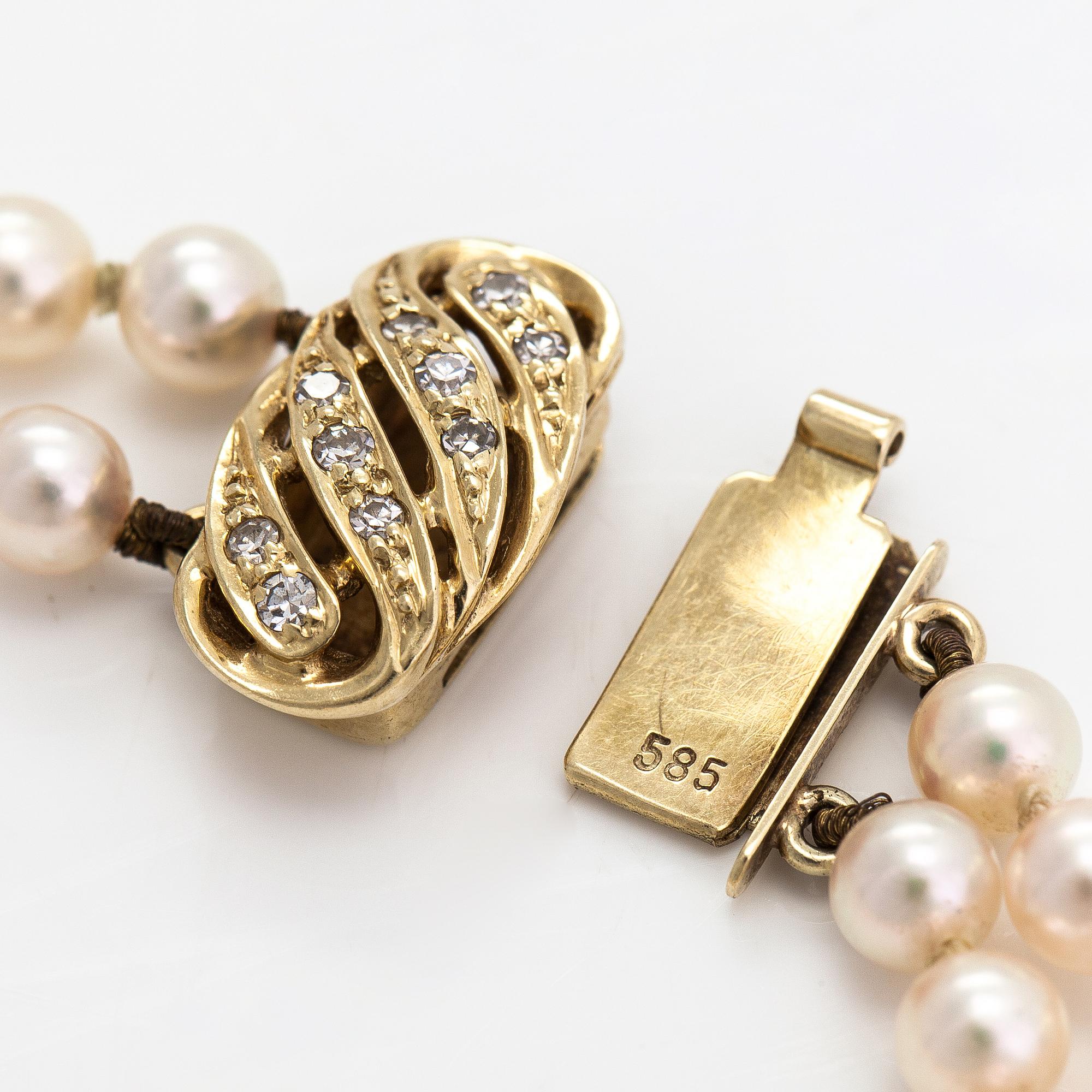 A 2-strand pearl bracelet with cultured pearls, lock 14K gold and diamonds, ca 0.13 ct in total.
