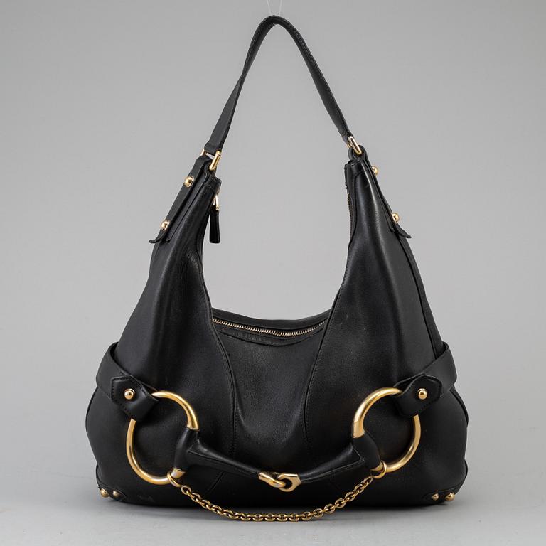 GUCCI, a leather horse-bit bag.