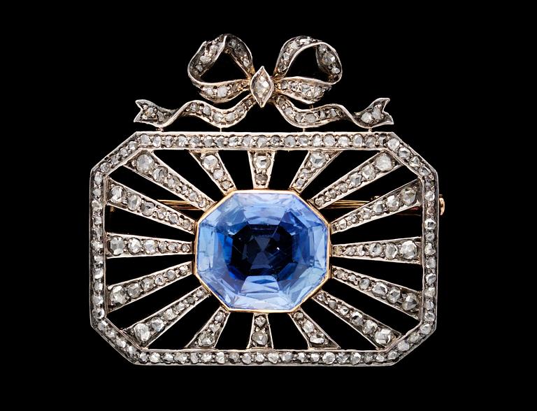 A platinum, diamond and blue sapphire brooch.
