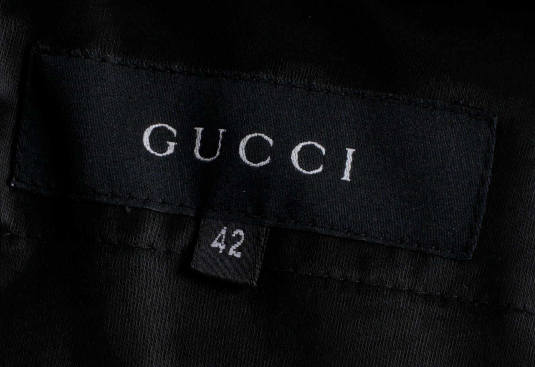 A two-piece black silk costume consisting of jacket and skirt by Gucci.