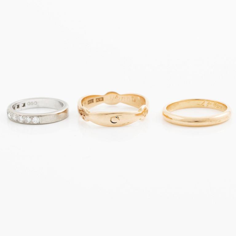 Rings, three pieces, gold, of which one set with brilliant-cut diamonds.