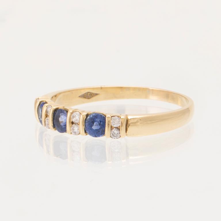 An 18K gold ring set with round brilliant-cut diamonds and round faceted blue stones, London England.