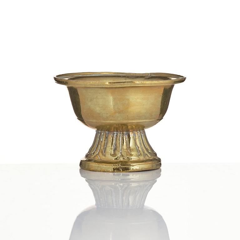 A bronze deity and a brass sacrificial bowl, Tibet, circa 1900.