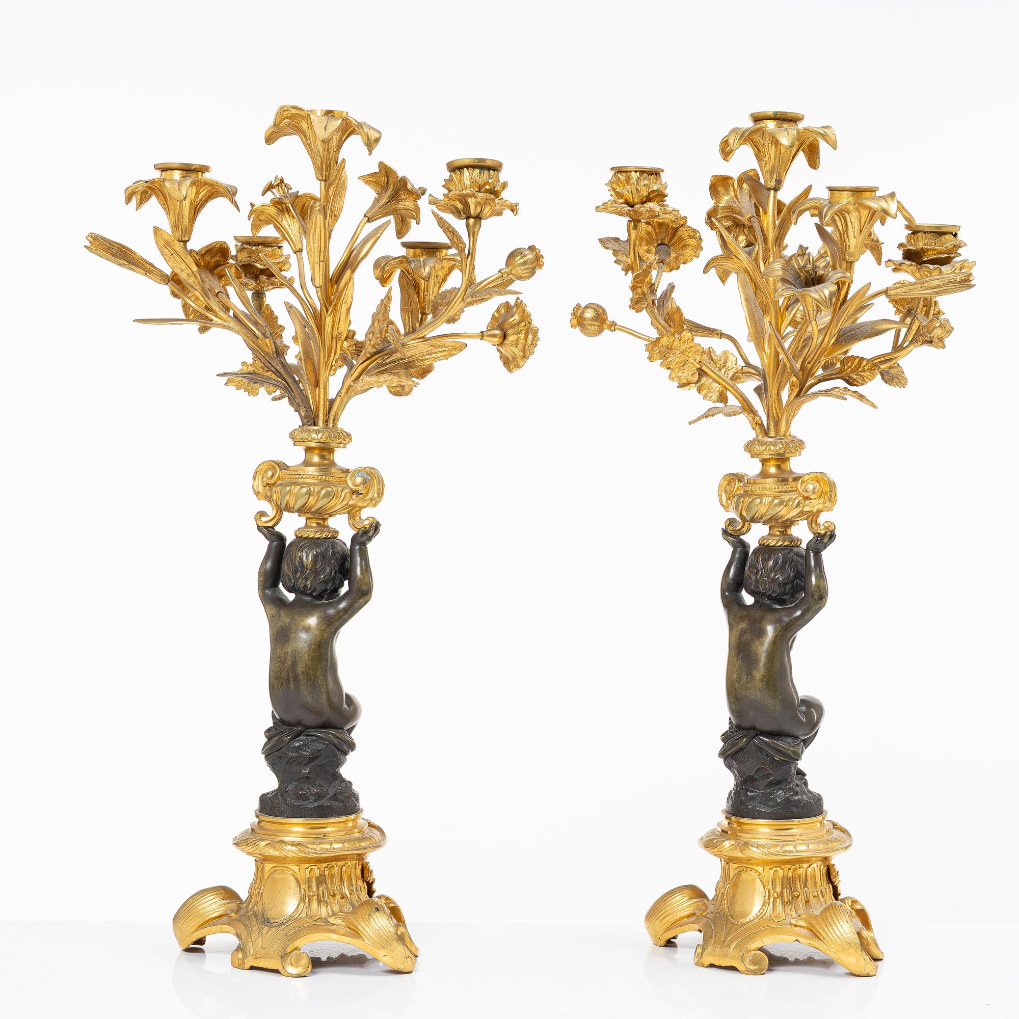 A Rococo style mantle clock and pair of candelabra, France, late 19th Century.