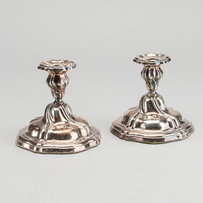 A PAIR OF SILVER ROCOCO STYLE CANDLE STICKS.