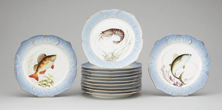 Twelve Danish Royal Copenhagen porcelain fish plates and a serving dish.