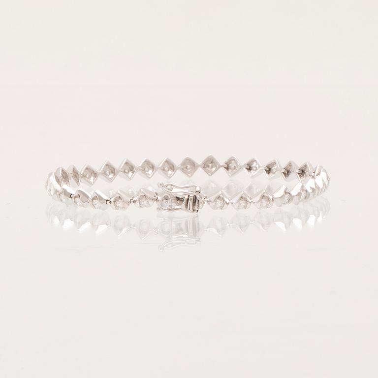 An 18K white gold tennis bracelet with round brilliant-cut diamonds.