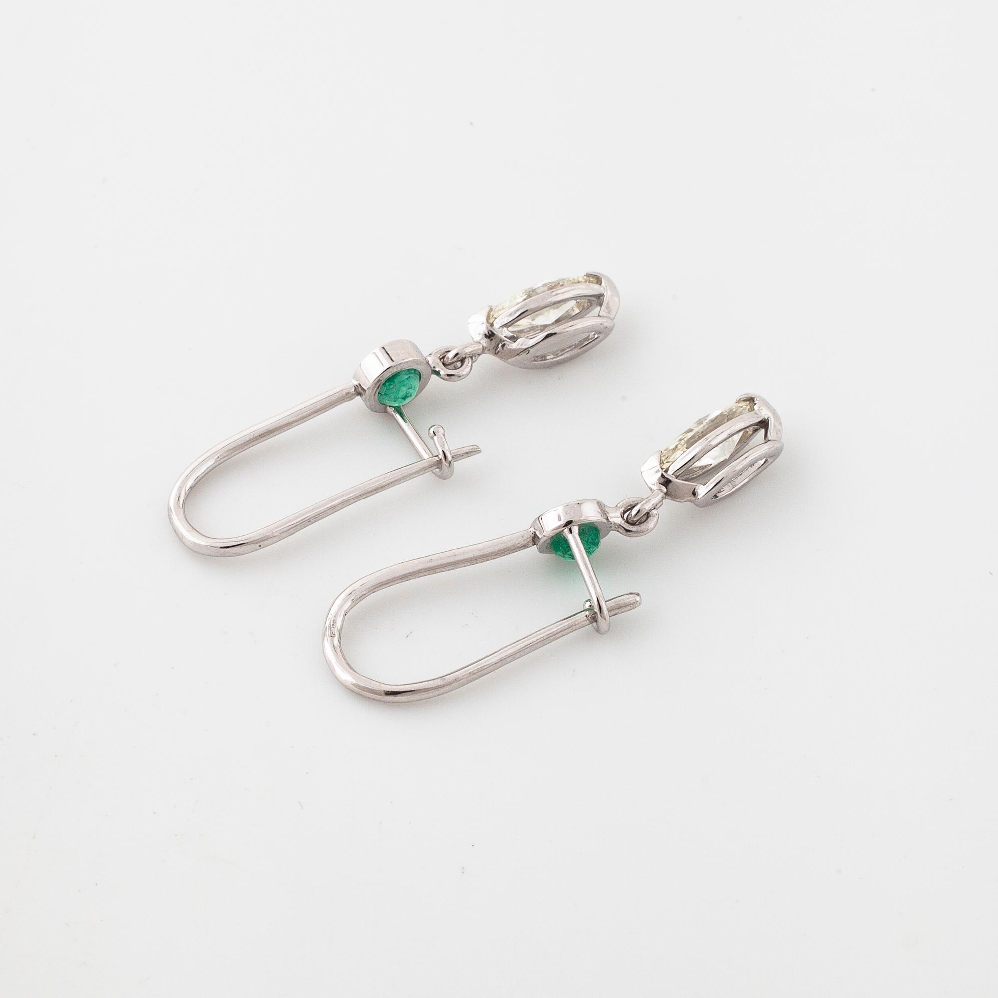 A pair of emerald and marquise cut diamond earrings.