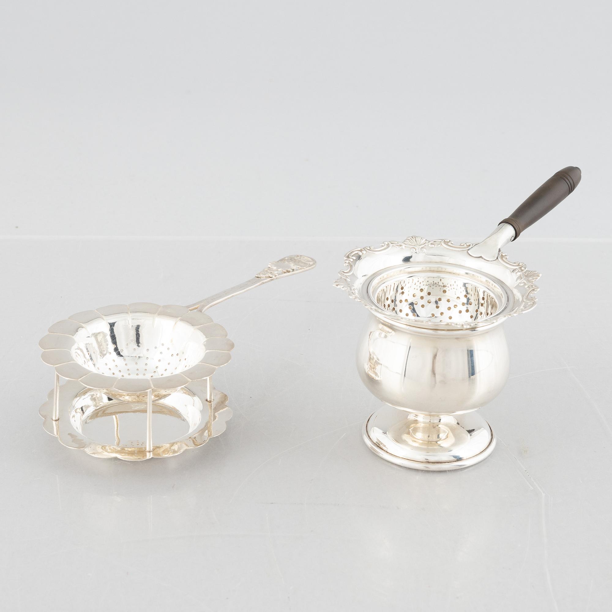 Two sterling silver tea strainers with stands, 20th century.