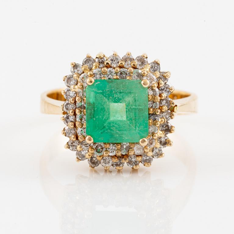 Ring in 18K gold set with a faceted emerald and round brilliant-cut diamonds.