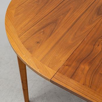 A round walnut veneered dining table.