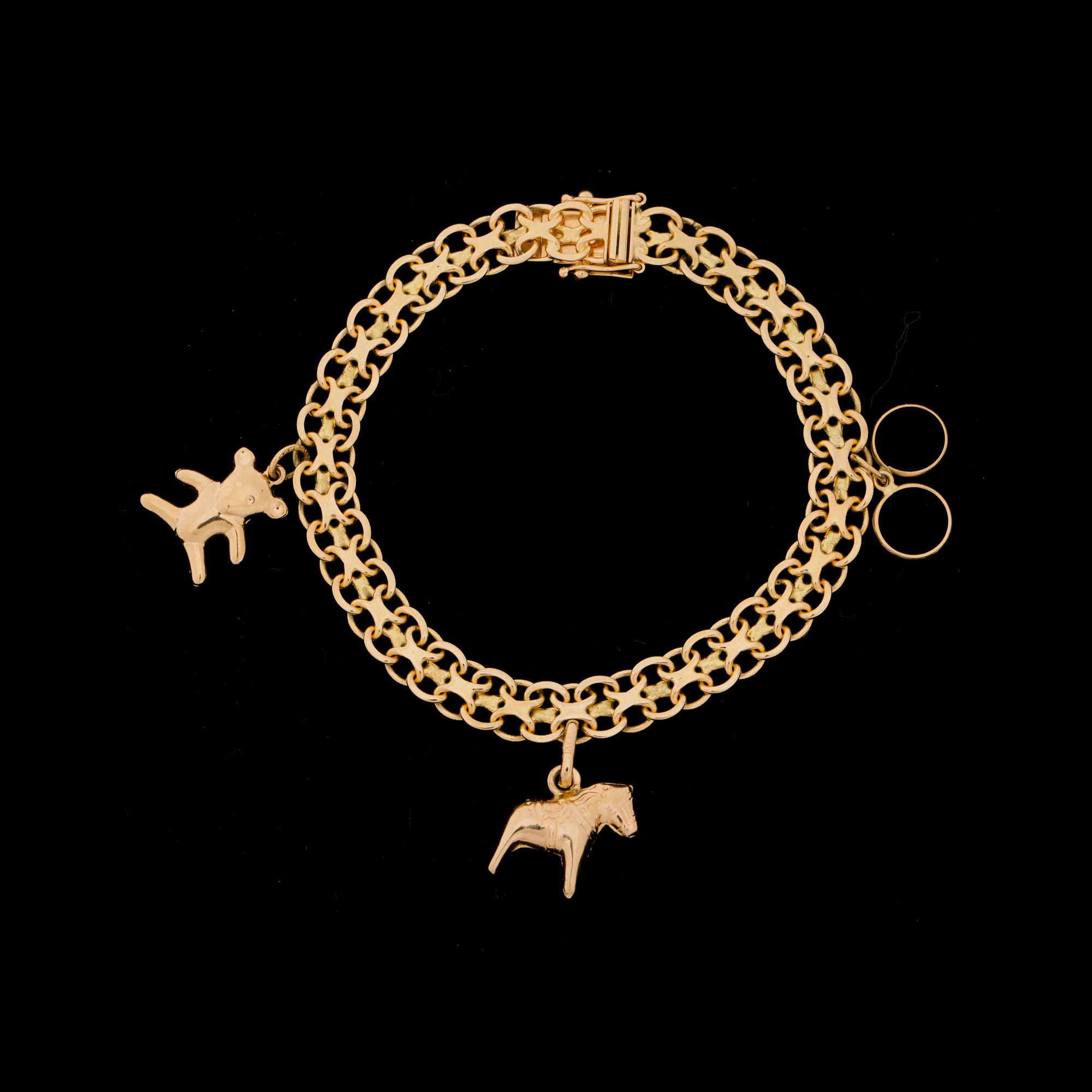 BERLOCKARMBAND, 18 k guld med 6 berlocker i 18 k guld. Vikt ca 18 g. Samt 2 berlocker i förgylld silver.