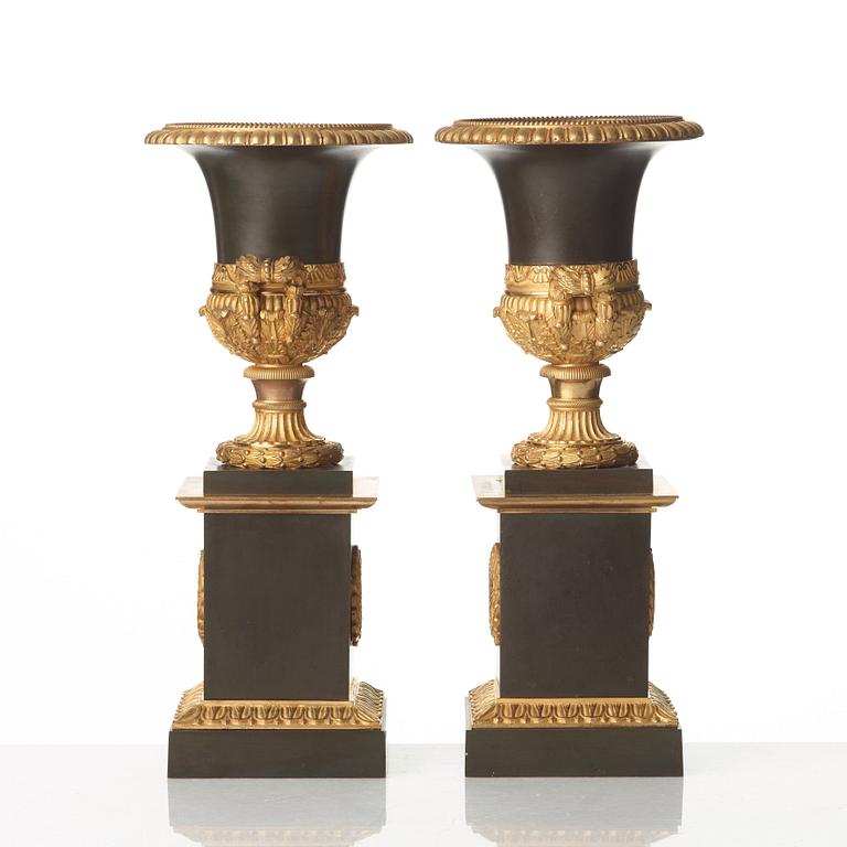 A pair of French Empire early 19th century gilt and patinated bronze urns.