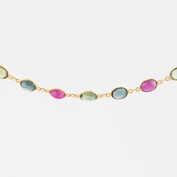 A necklace set with oval, mixed-cut, multi-coloured gemstones.