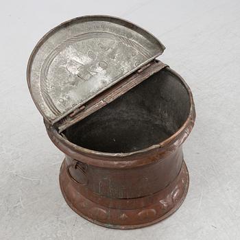 A copper water container, dated 1706.