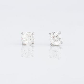 A pair of brilliant cut diamond earrings.