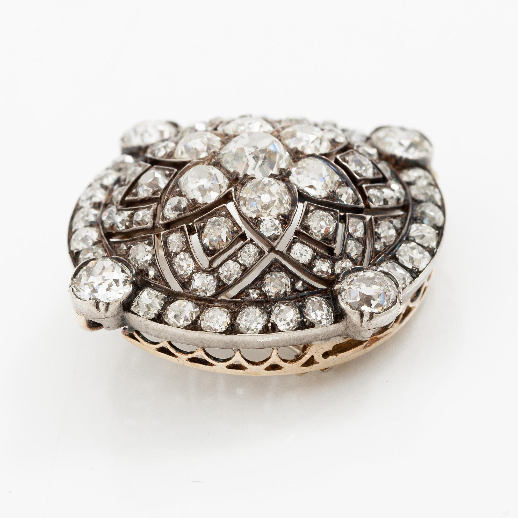 A brooch/pendant in gold and platinum with old-cut diamonds.