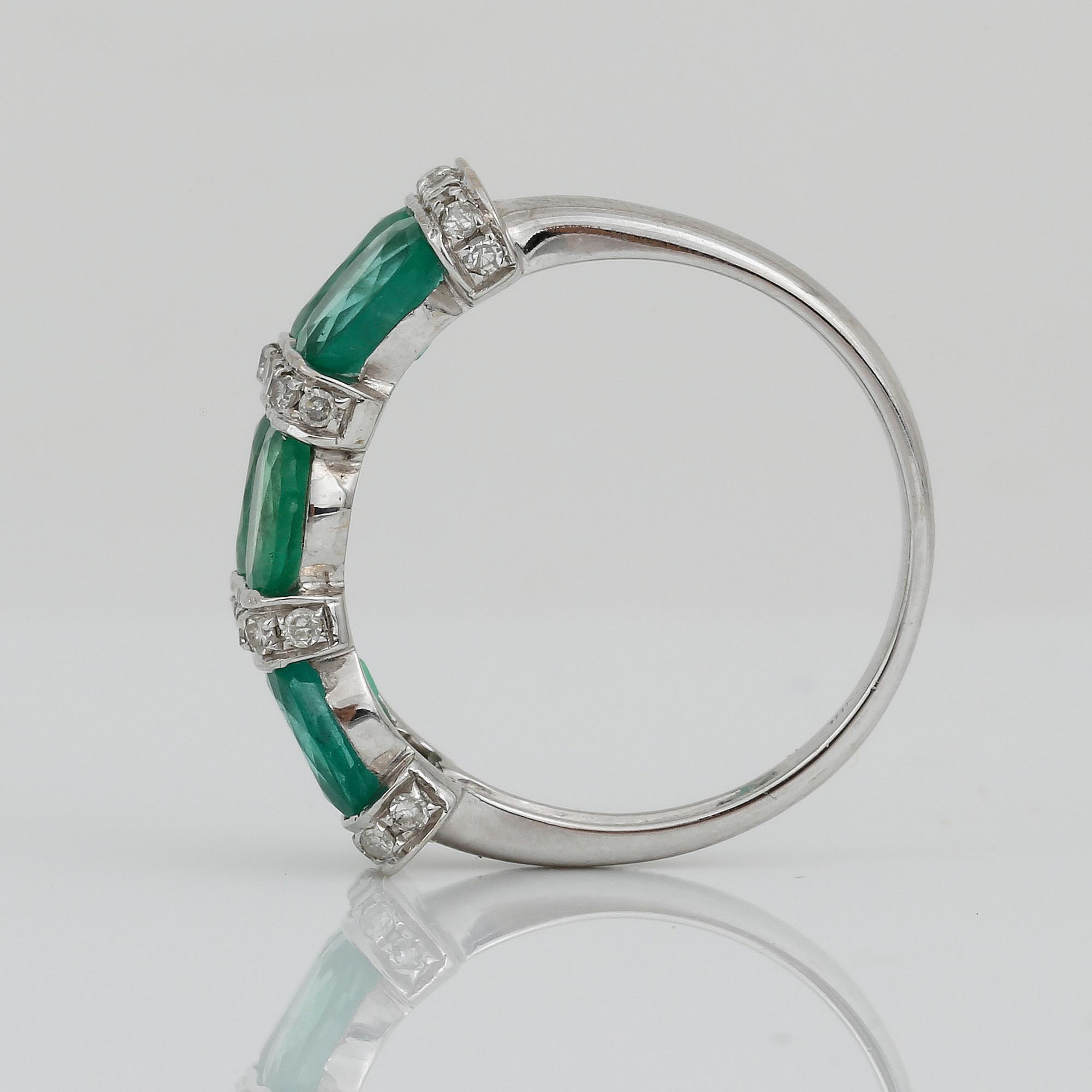 RING, 18K vitguld med ovalslipade, möjligtvis syntetiska smaragder, tot ca 1,98 ct samt små diamanter. Vikt ca 3,45 g.