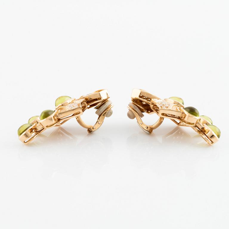 A pair of cabochon cut peridot and round brilliant cut diamond earrings.