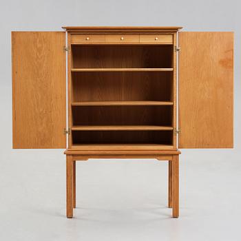 A Swedish Modern oak cabinet on stand attributed to Oscar Nilsson, 1940's.