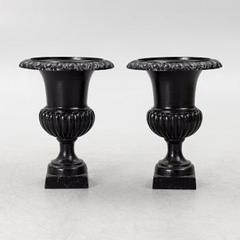 A pair of cast iron garden urns, 20th century.
