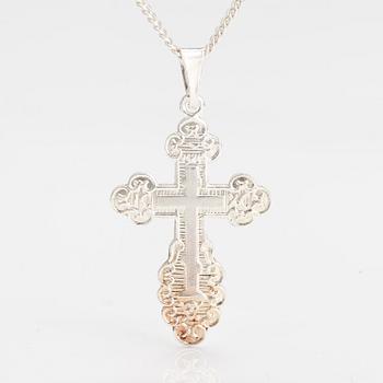 A stelring silver necklace with a cross.