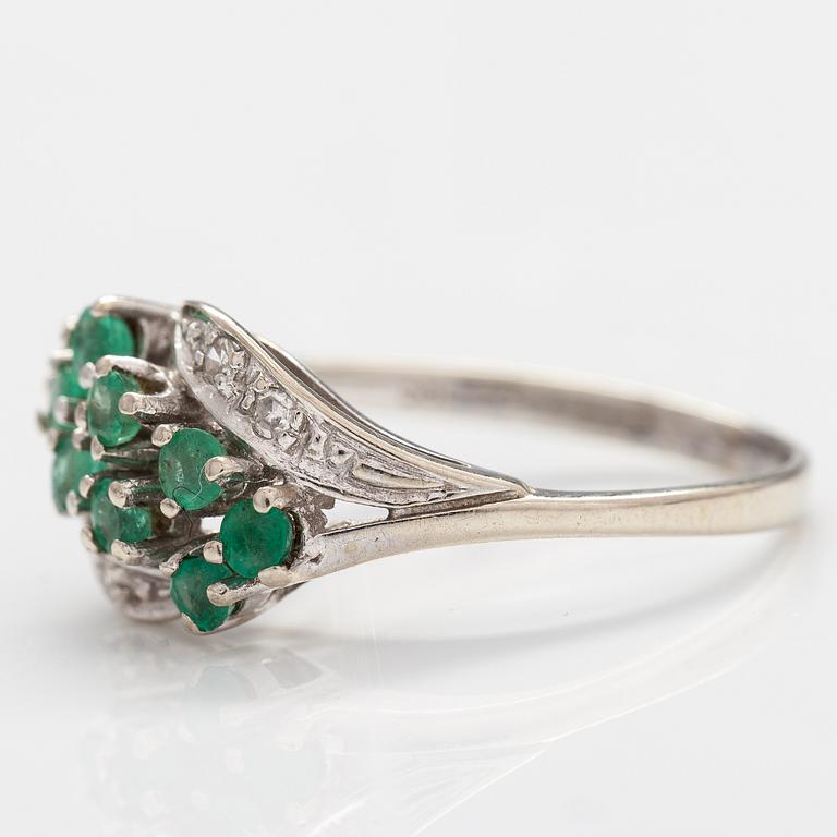 A 14K white gold ring with emeralds and diamonds ca. 0.02 ct in total. Import marked Turun Hopea, Turku 1995.