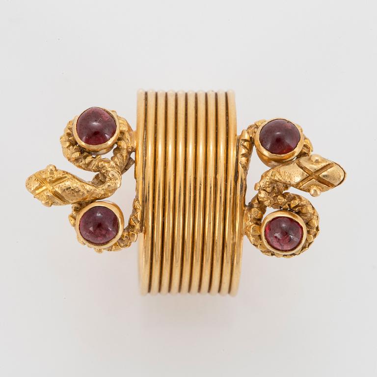 An 18K gold ring set with cabochon-cut garnets design Ilias Lalaounis.