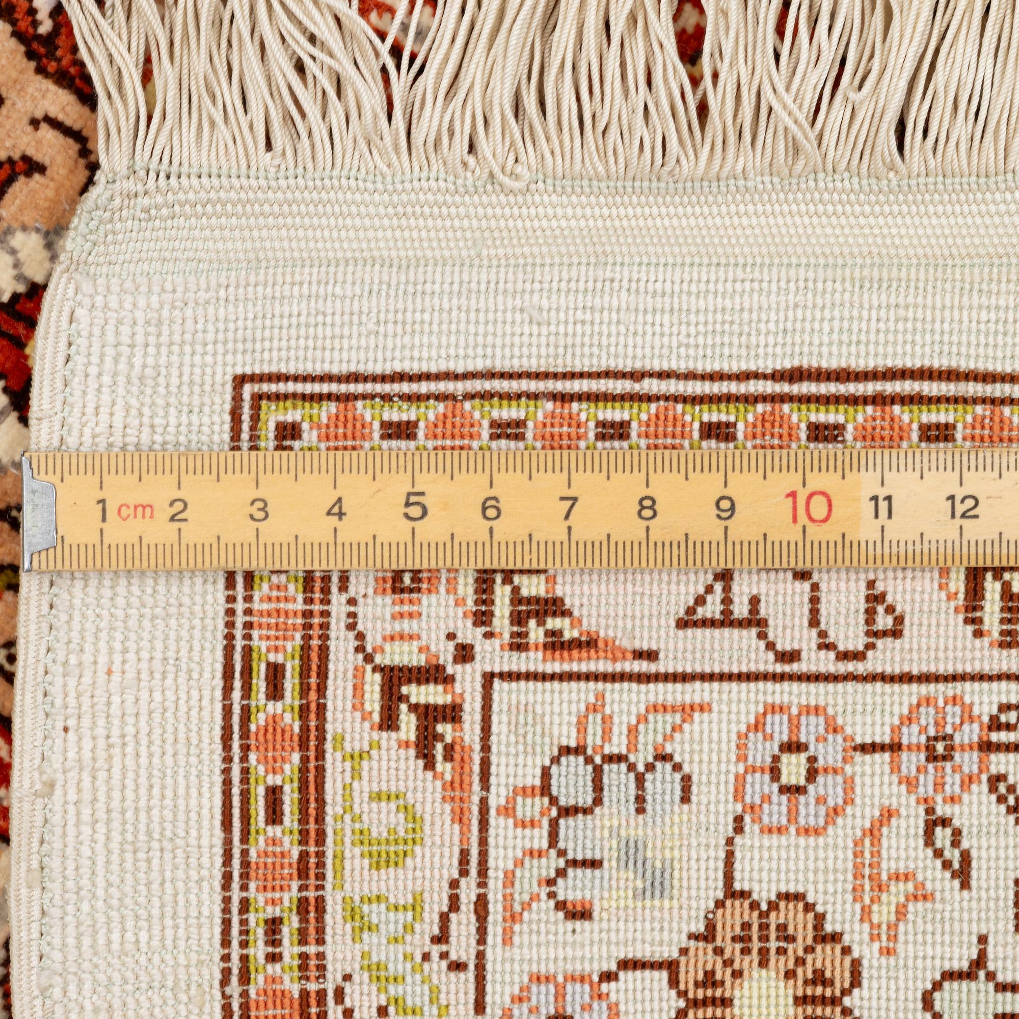 A Hereke silk rug, West Anatolia, c. 107 x 69 cm.