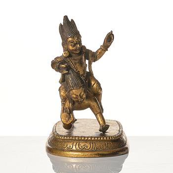 A small gilt bronze figure wrathful deity riding on a corpse, Tibeto-Chinese, 18th Century.