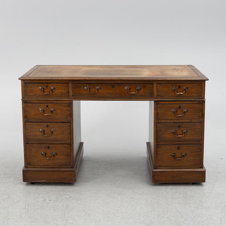 A mahogany and mahogany veneer desk with desk chair, 20th Century.