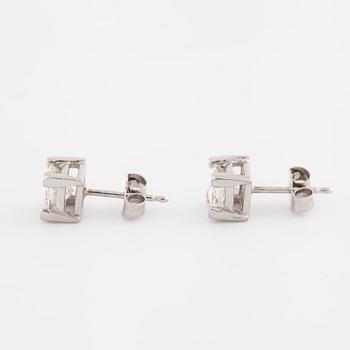 A pair of princess cut diamond earrings.