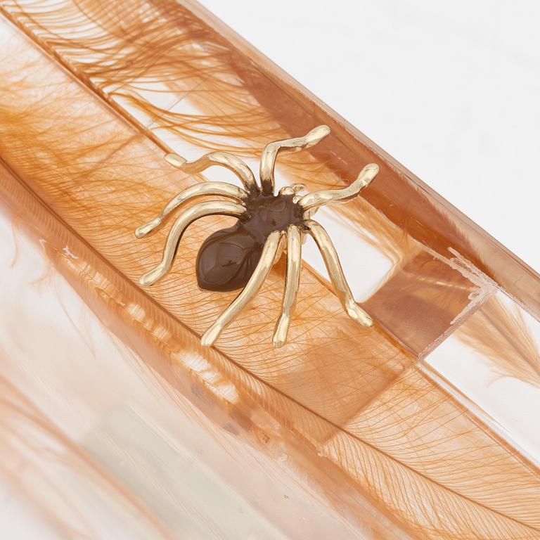 Charlotte Olympia, a transparent clutch with feathers and a spider.