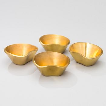 A set of four brass ashtrays, designed in 1947.