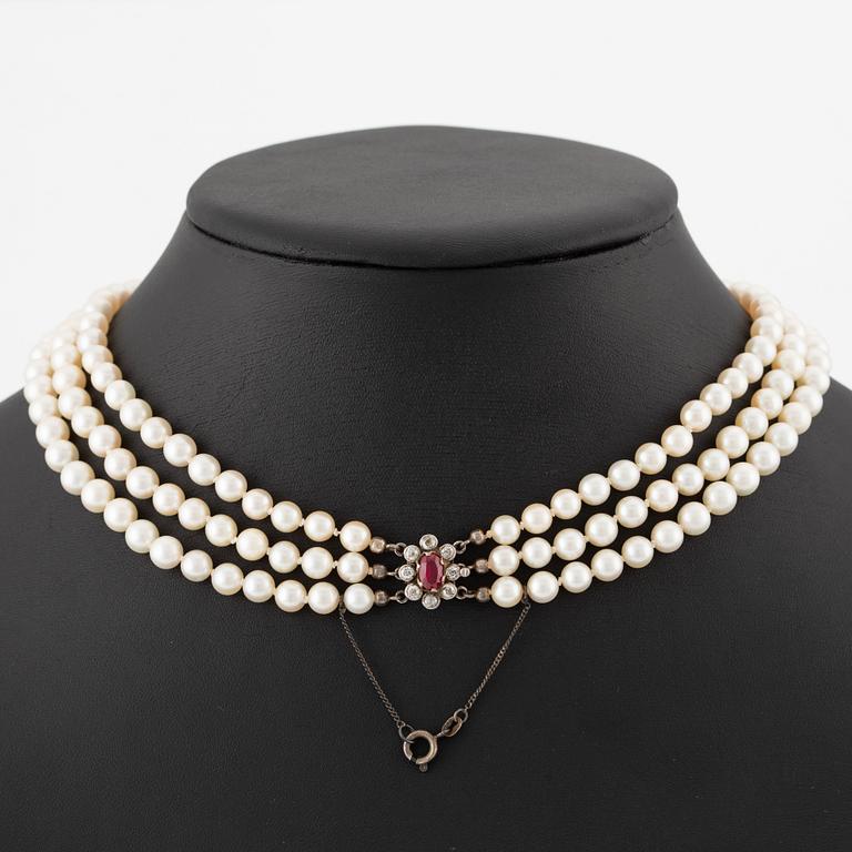 Pärlcollier, treradigt, med doserade odlade pärlor, guld med gammalslipade diamanter och syntetisk rubin.